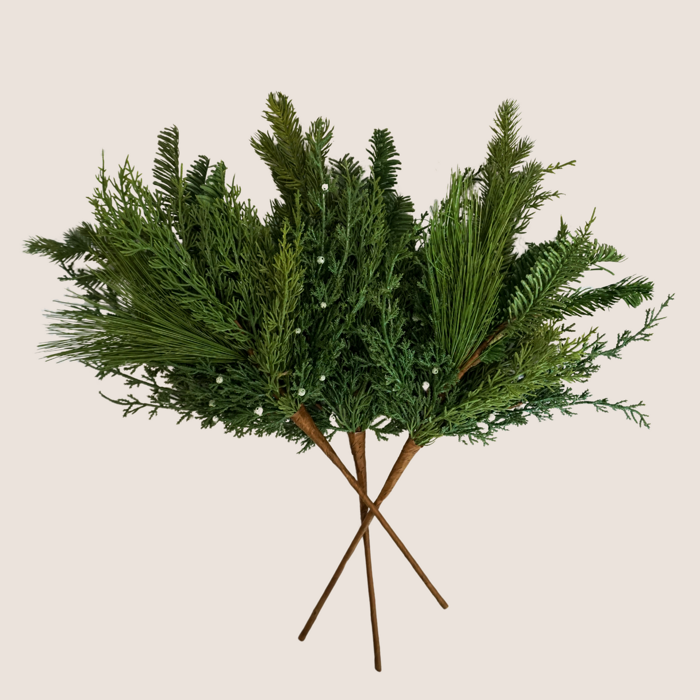 3 stems of artificial mixed evergreen stems featuring mix of juniper, cedar, balsam fir, and ponderosa pine against blush background.
