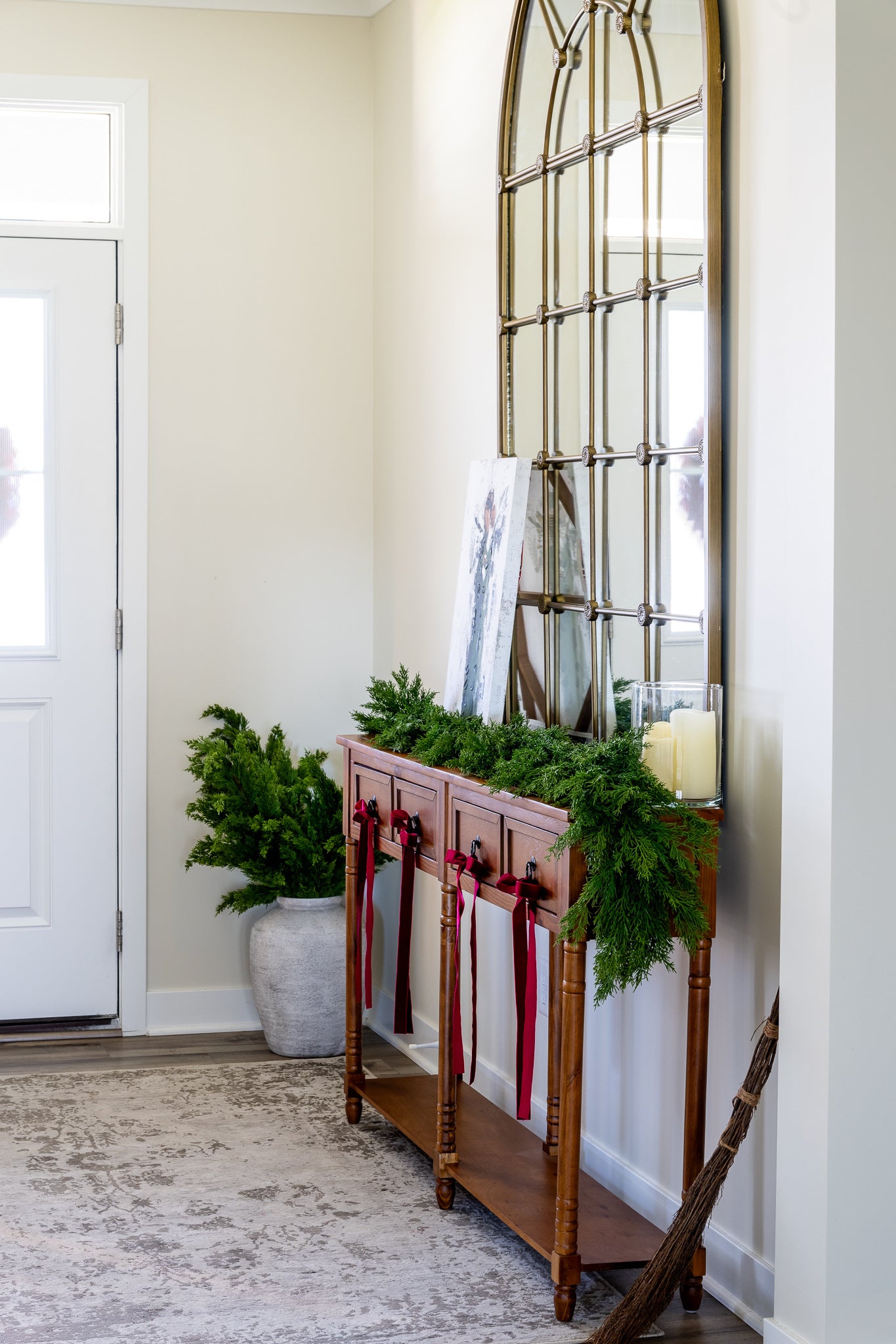 Artificial evergreen cedar garland on console table at density of faux cedar garland at half full density.