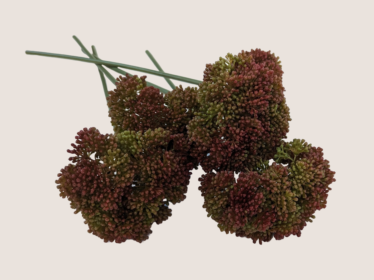 Bouquet of artificial  fall allium spray flower against a beige background showcasing predominantly dark red blooms with gradients of green, mauve, and brown creating lifelike faux flower.