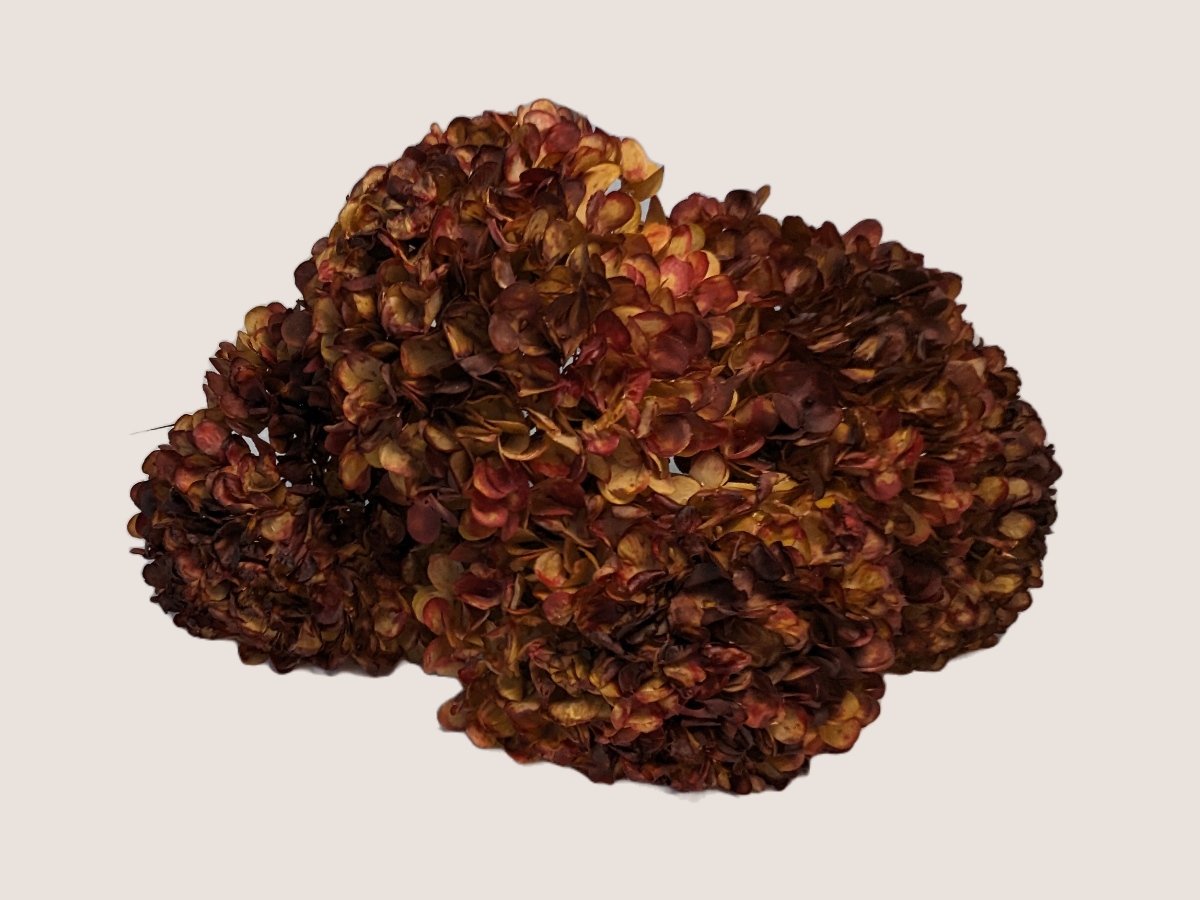 Artificial fall hydrangea flower bouquet against a light beige background showcasing realistic look dried florals and leaves.