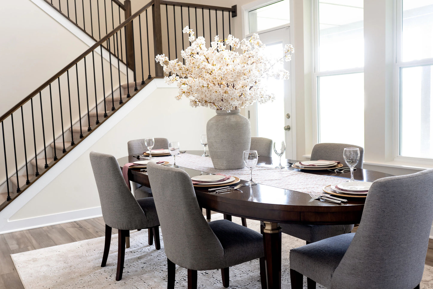 Artificial cherry blossoms in dining room with large statement tablescape.