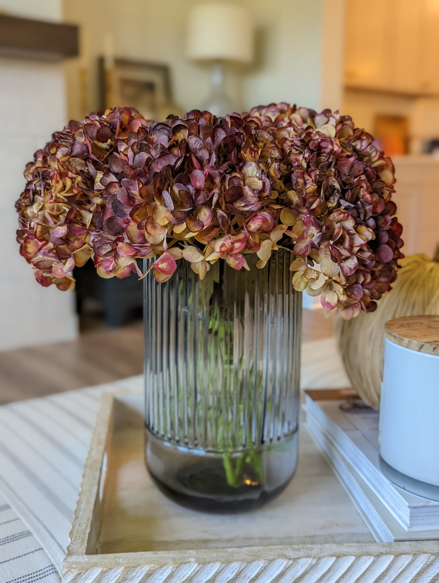 Artificial fall hydrangea flower bouquet with colors of burgundy, red, & brown petals in fluted grey vase showcasing realistic look dried florals and leaves.