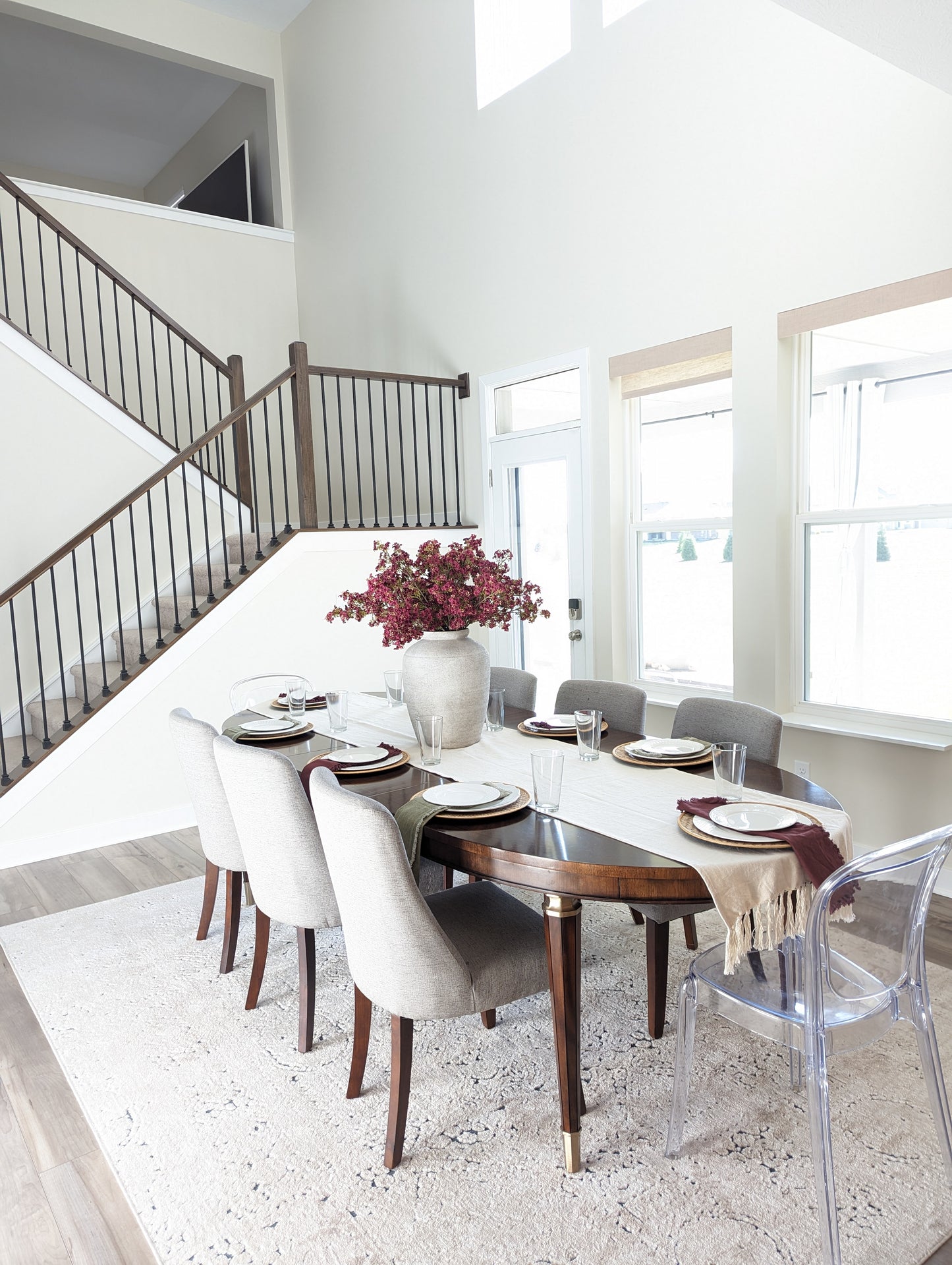 Artificial dark pink burgundy fall stem with light pink accents and realistic branch bouquet in lifestyle dining room setting.