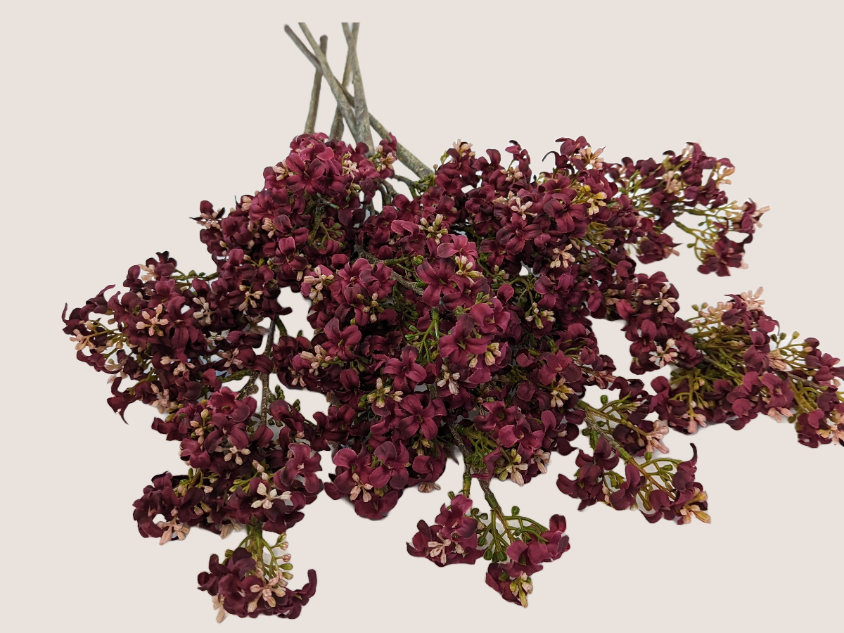 Artificial dark pink burgundy fall stem with light pink accents and realistic branch against a beige backdrop.