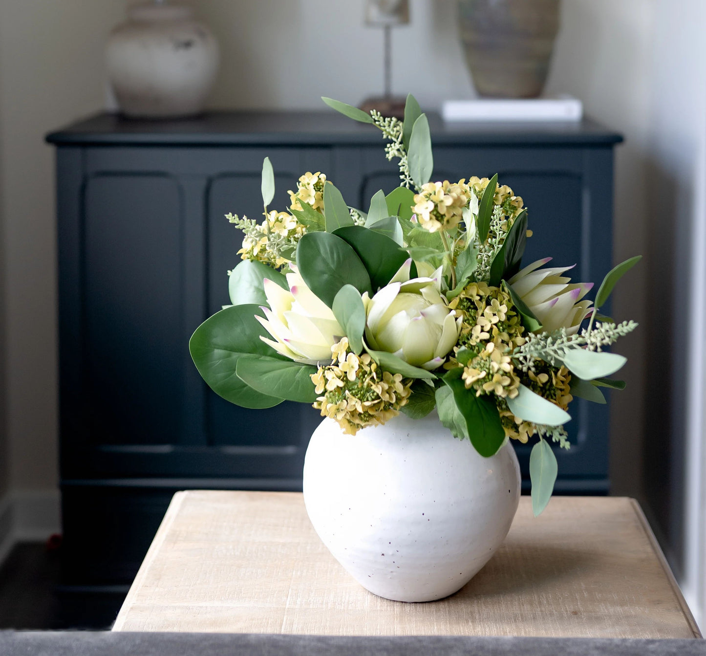 White speckled ceramic vase with summer arrangement of flowers.