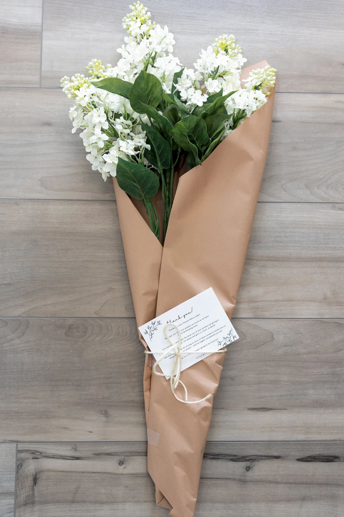 Artificial white lilac flowers in market packing.