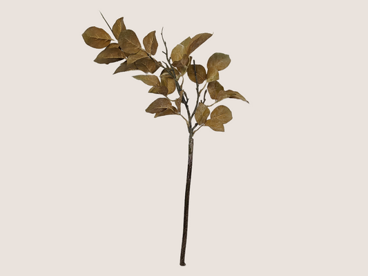Artificial dried look golden leaf branch for fall home decor with realistic brown stem against beige background.