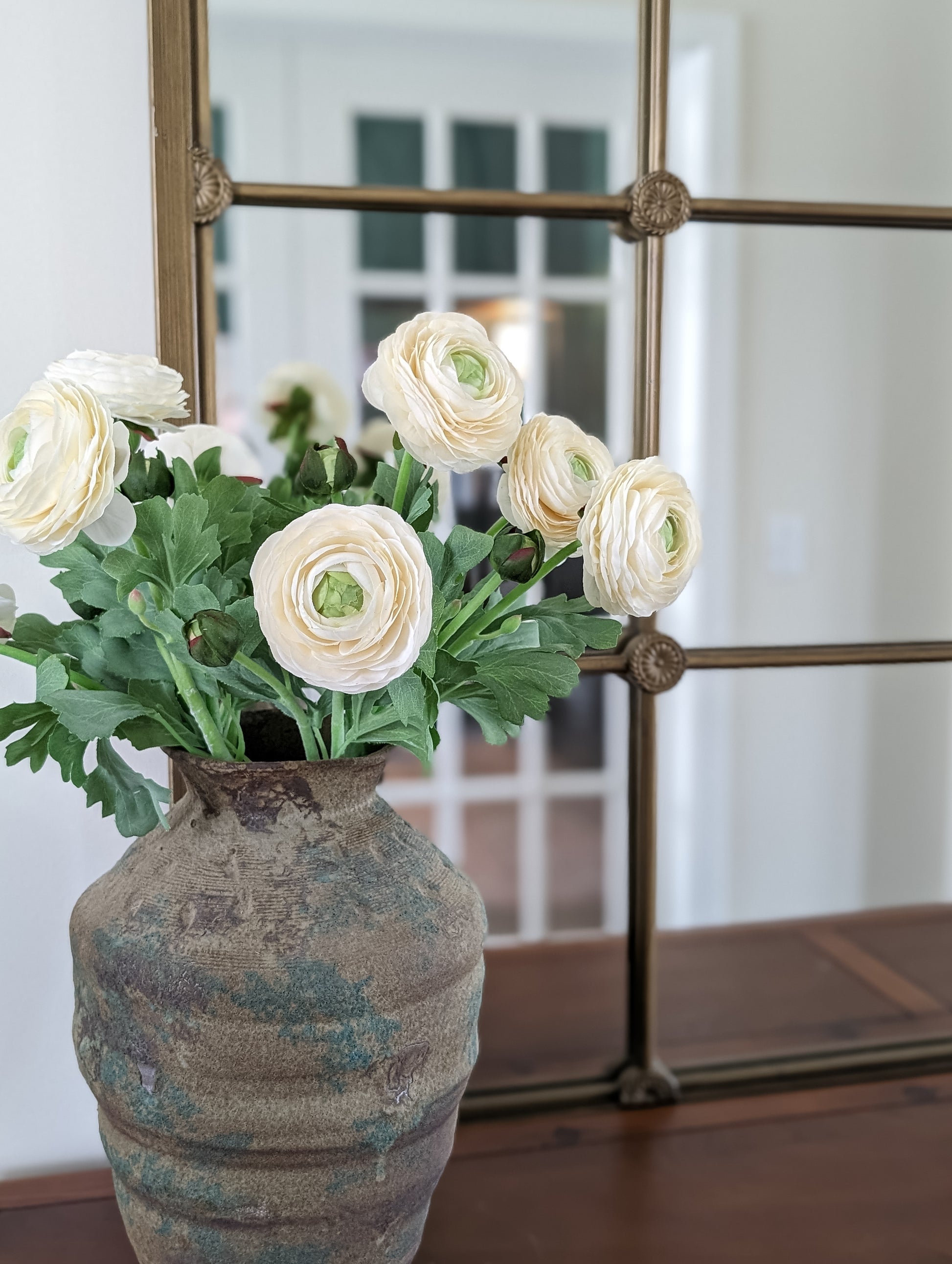 Set of 6 artificial real touch blooming ranunculus flower in ivory, styled in vintage terra cotta vase against mirror.
