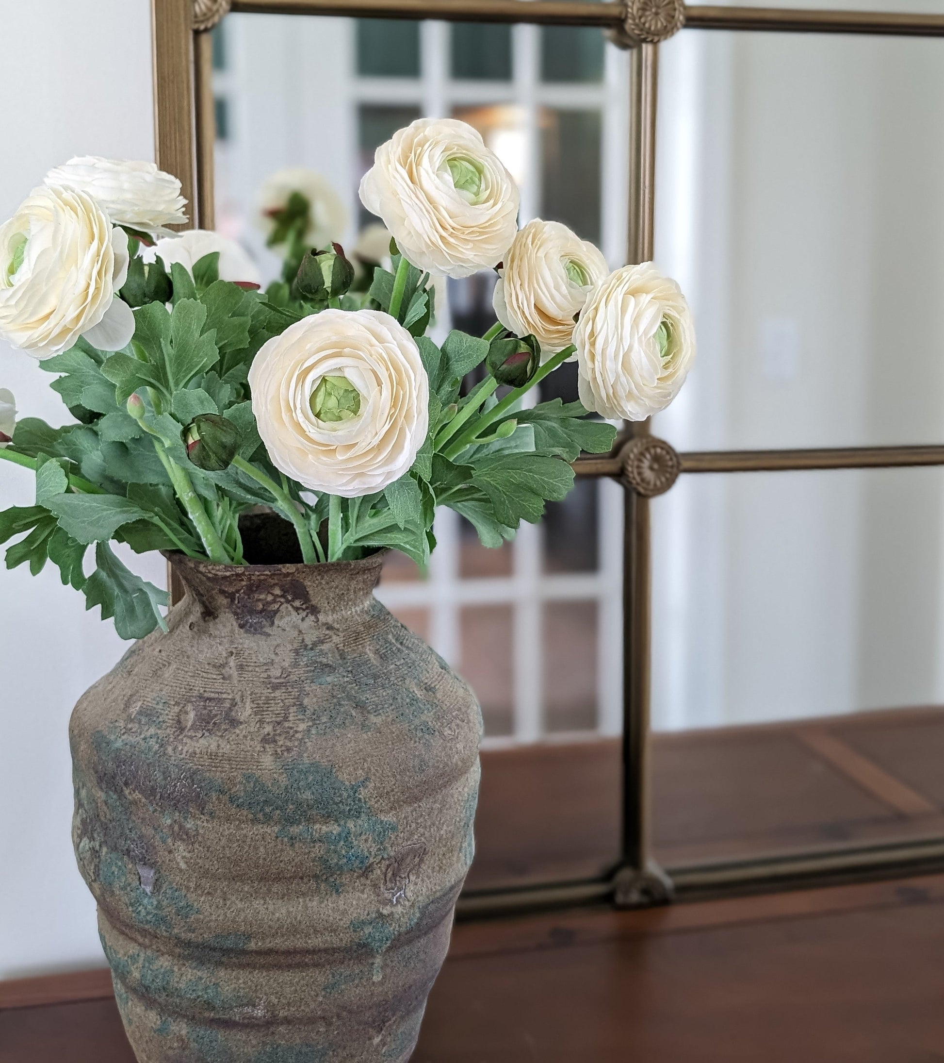 Set of 6 artificial real touch blooming ranunculus flower in ivory, styled in vintage terra cotta vase against mirror.
