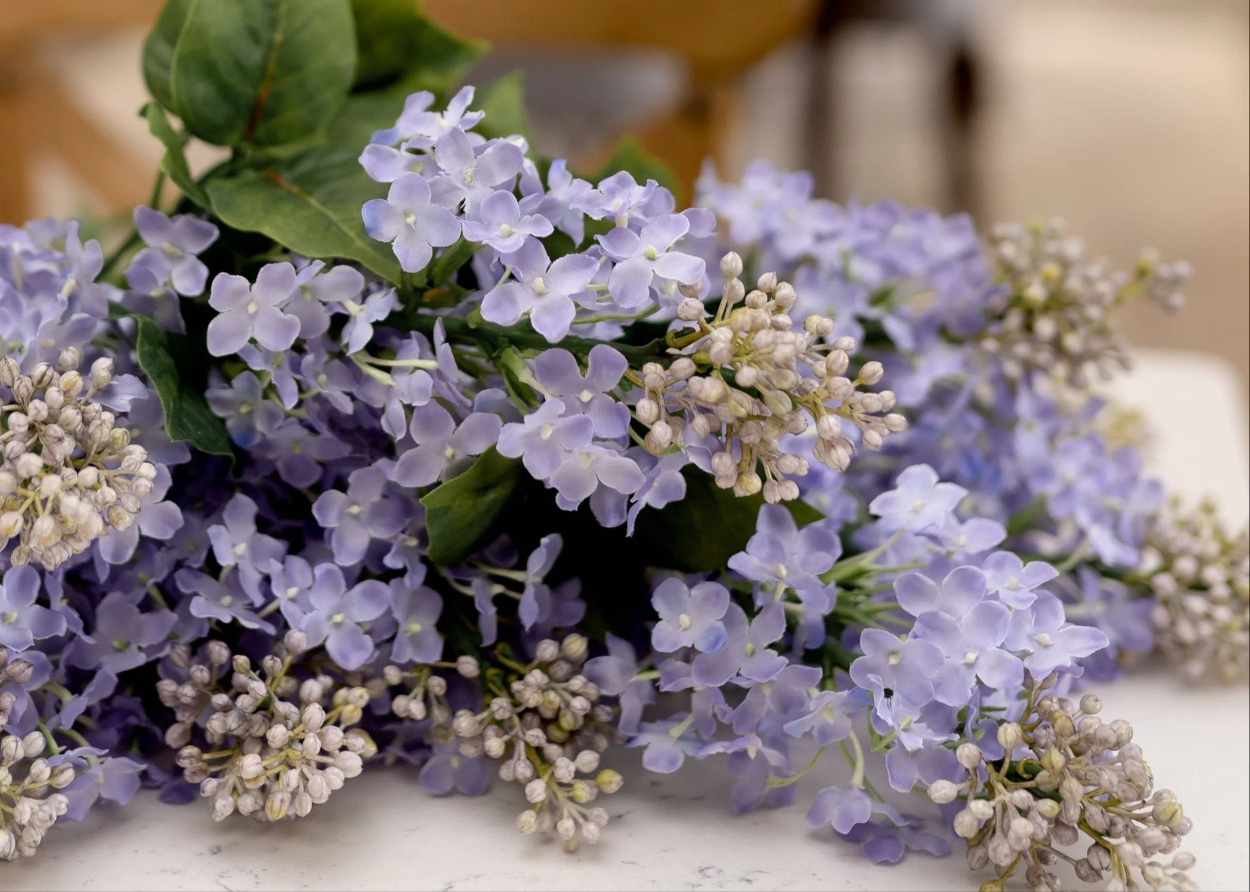 Close up of artificial lilac purple flowers featuring buds and blooms in lavender lilac color.