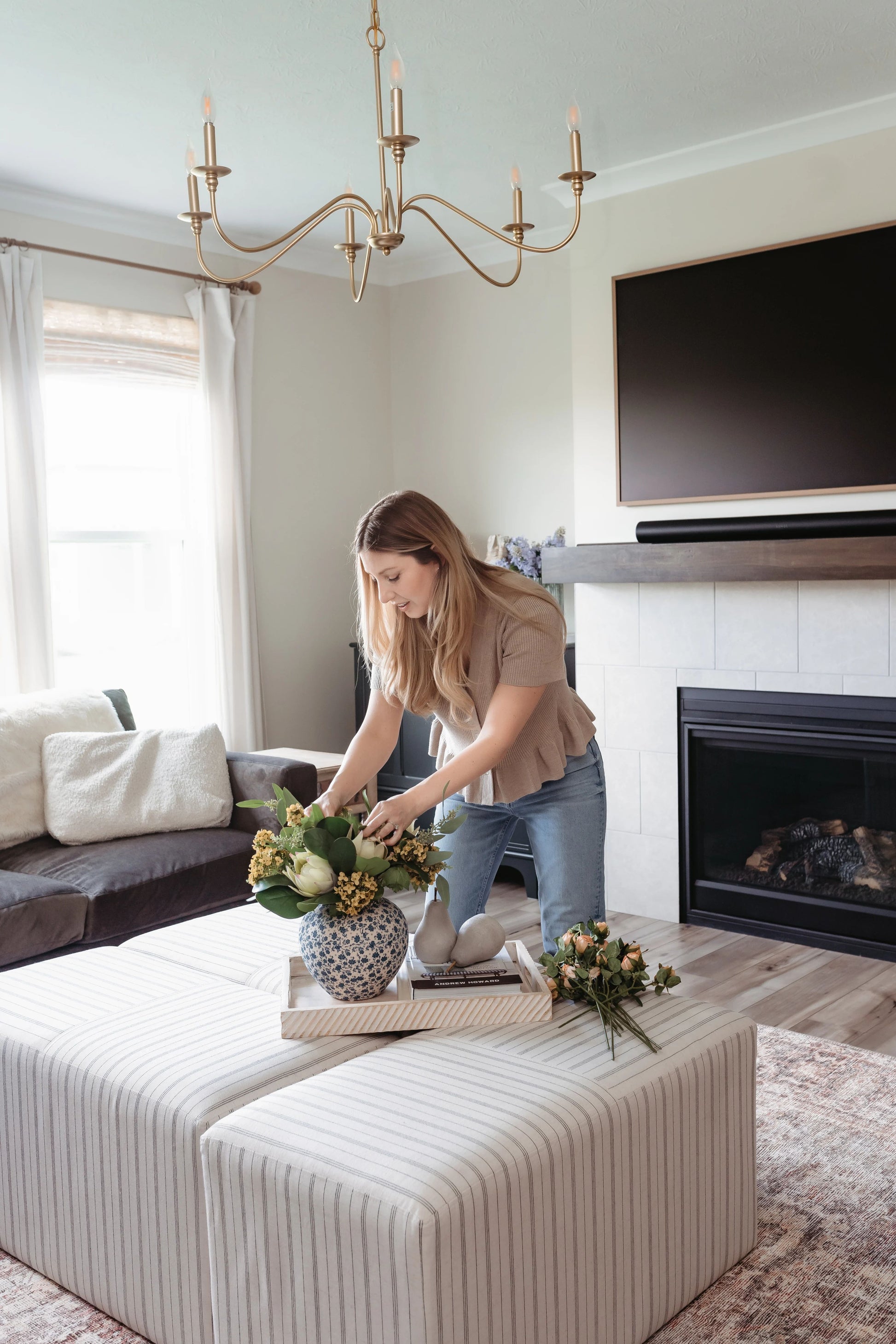 King protea flowers featured in summer bouquet being styled in living room on coffee table.