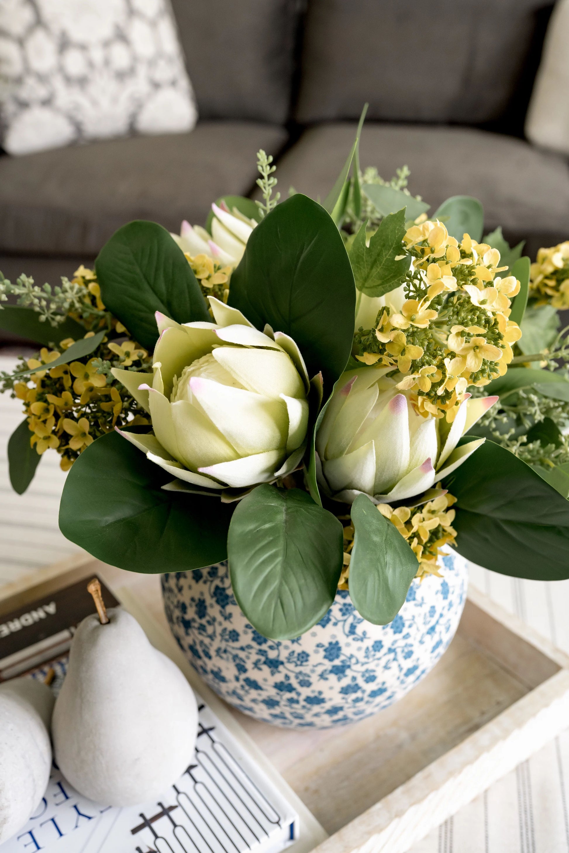 Summer bouquet featuring yellow hydrangeas and king protea flowers.