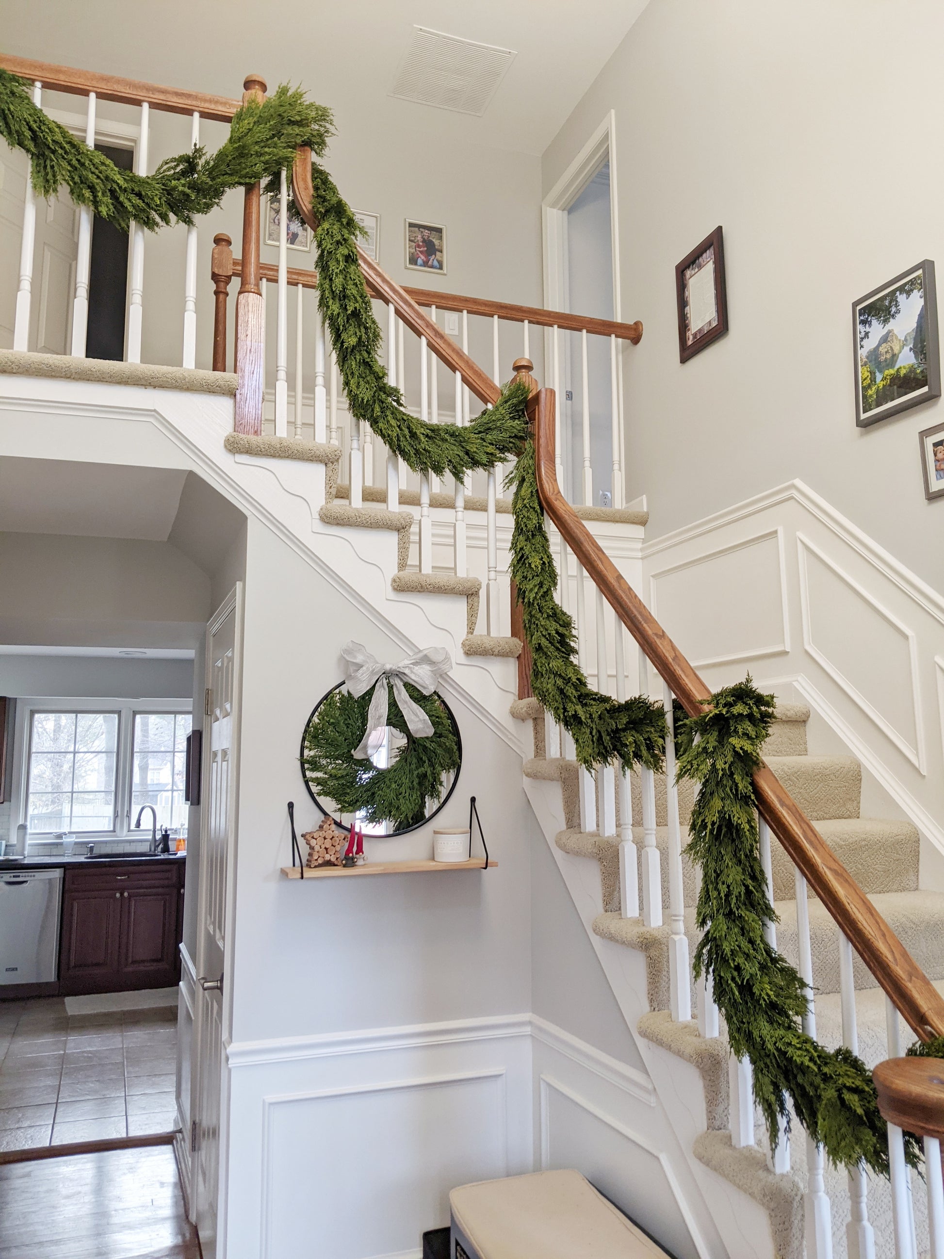 Image of 9 ft artificial real touch cedar garlands hanging in front foyer of home for holiday and Christmas decorating.