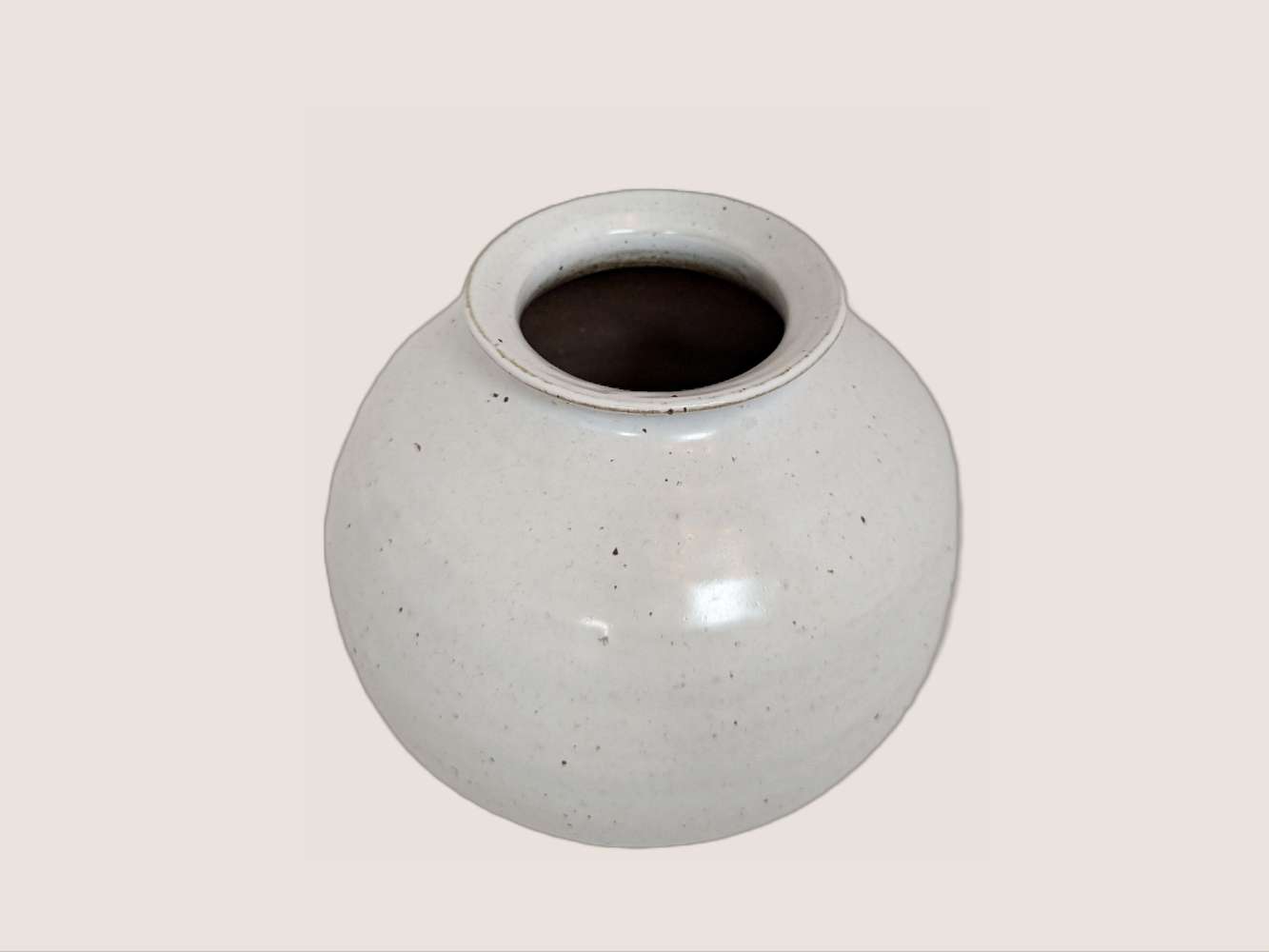 white ceramic vase in round shape, 8 inches tall and 8 inches wide at largest width, with 3.5 inch vase opening. Brown and black speckles give it natural texture and look.