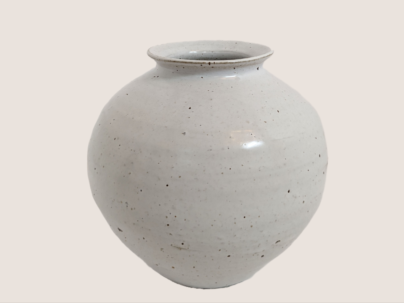 Ivory ceramic vase in round shape with 3.5 inch vase opening. Brown and black speckles give it natural texture and look.