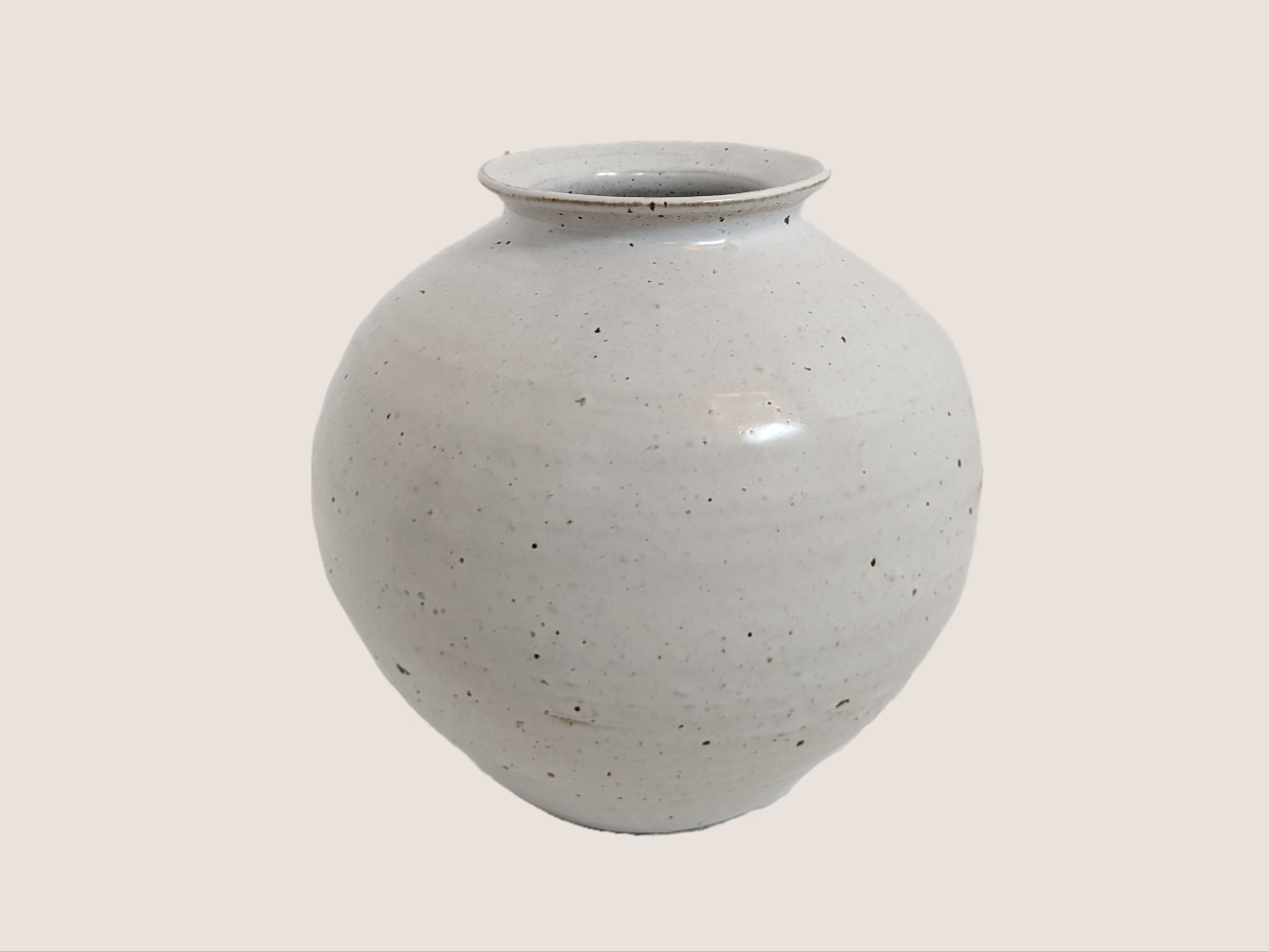 Ivory ceramic vase in round shape, 8 inches tall and 8 inches wide at largest width, with 3.5 inch vase opening. Brown and black speckles give it natural texture and look.