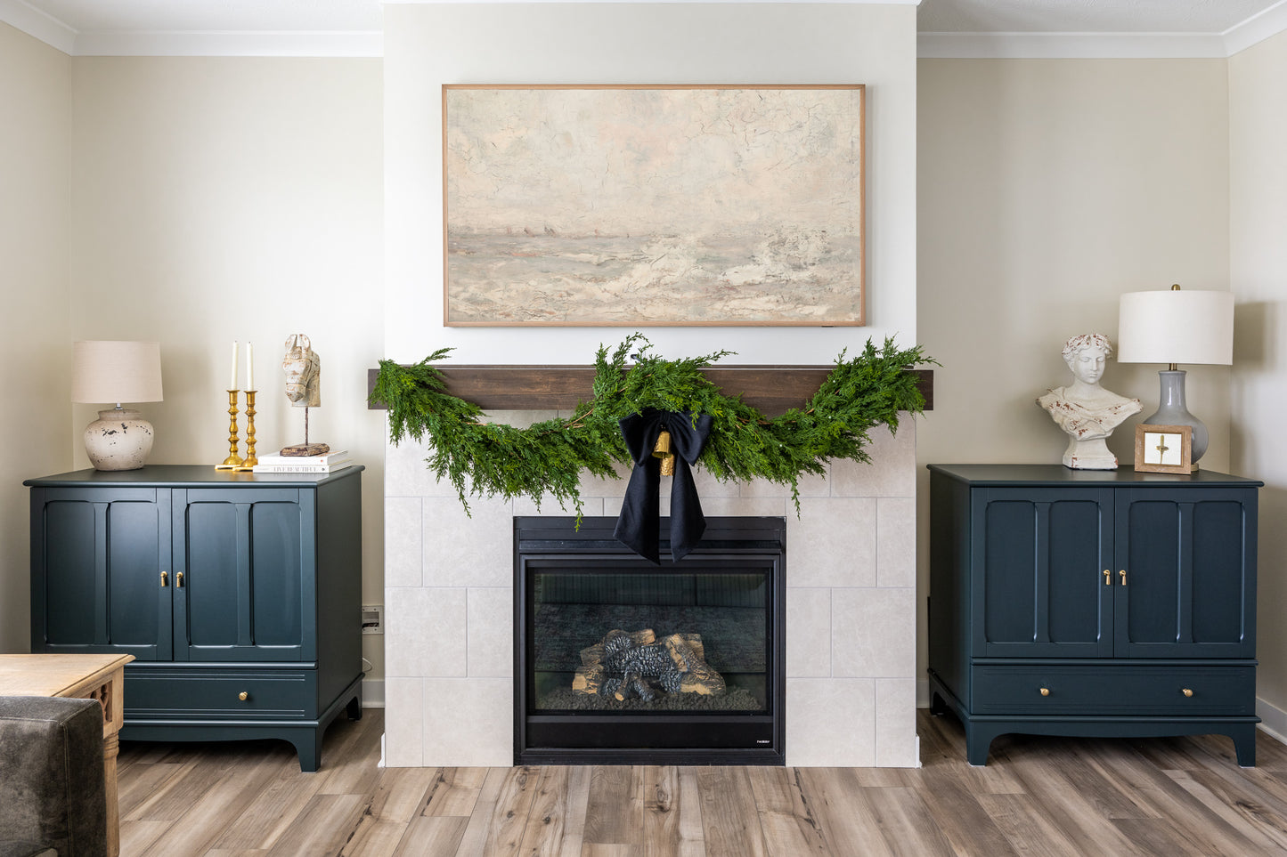 Winter berry holiday garland draped across mantle layered with faux cedar garland featuring white blue juniper berries.