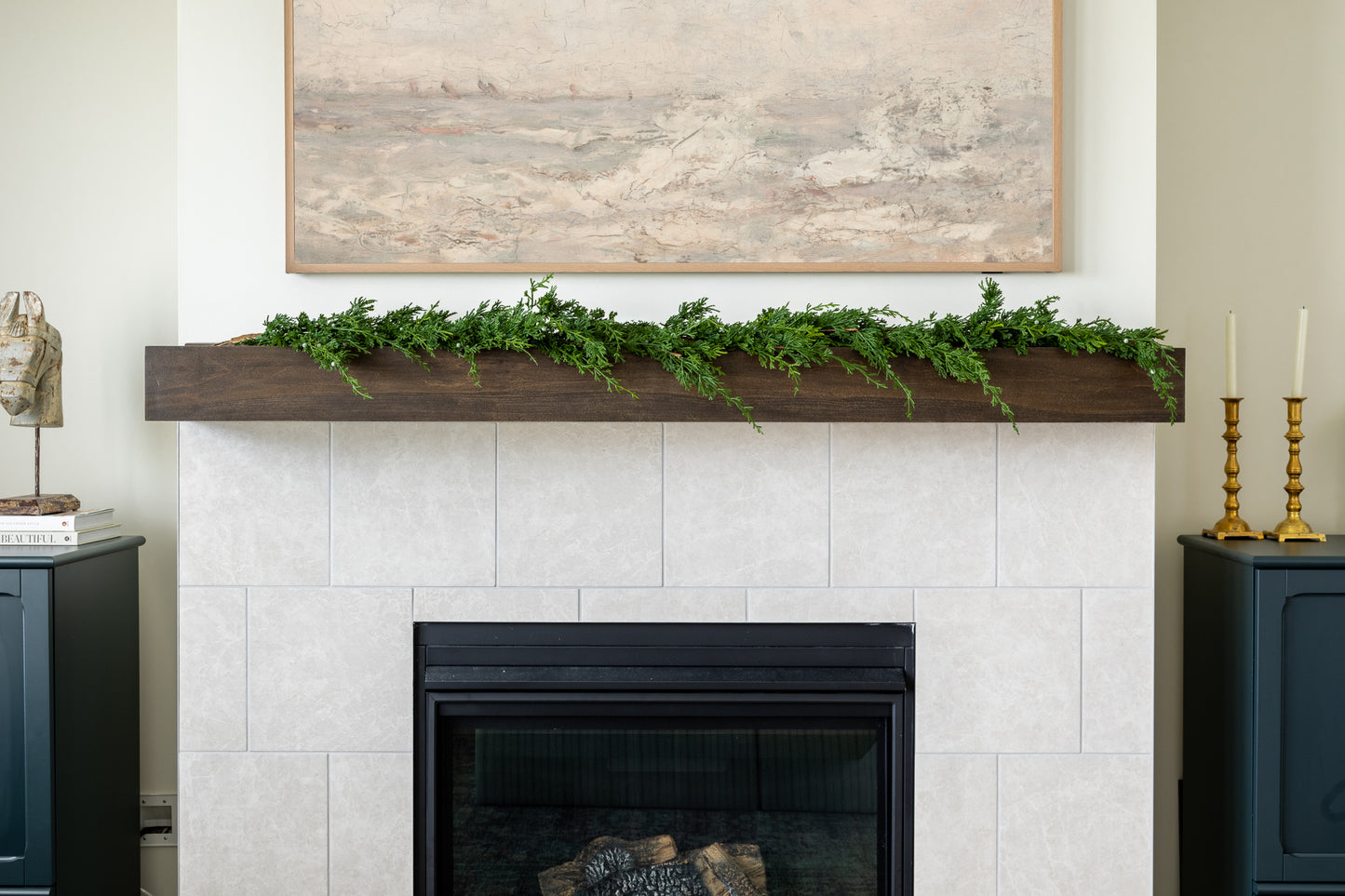 Winter berry Christmas garland draped across mantle with mixed greenery featuring white blue juniper berries.