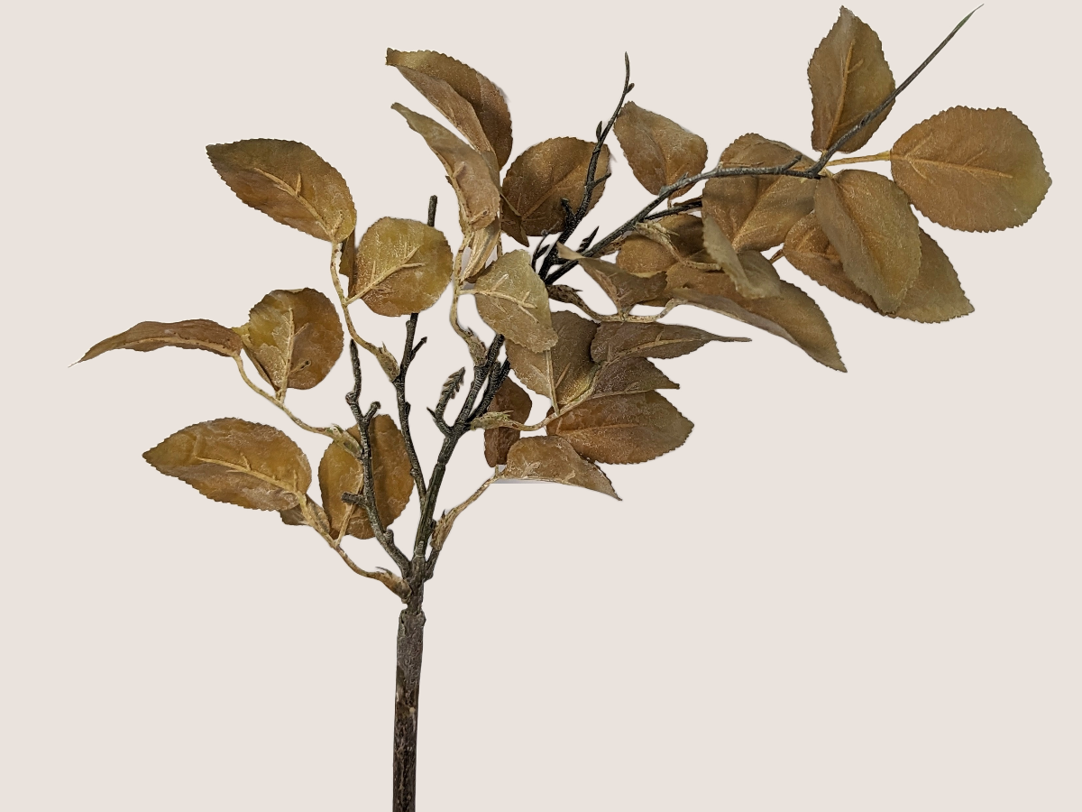 Close up of artificial dried look golden leaf branch for fall home decor with realistic brown stem against beige background. 