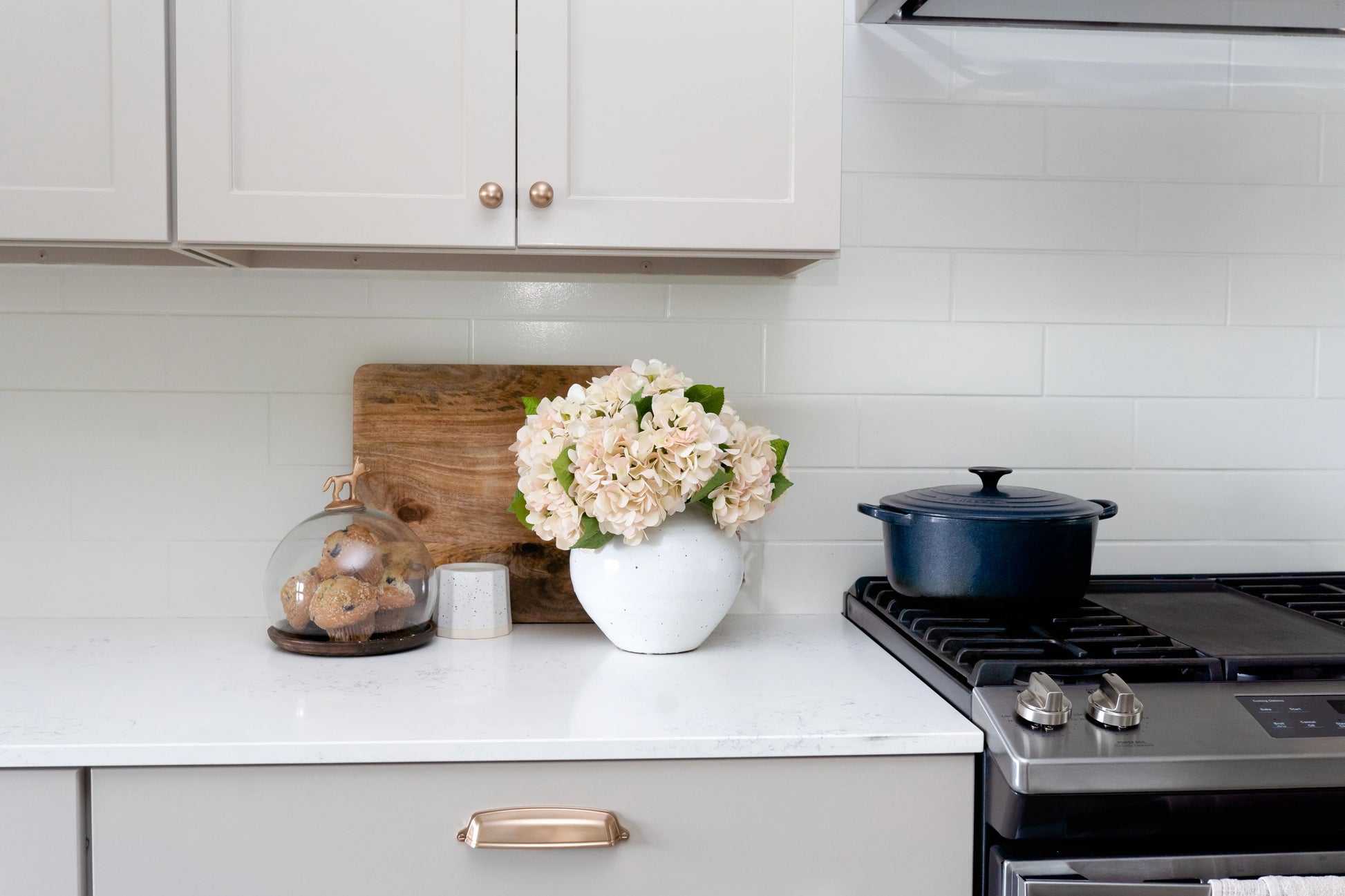 White ceramic vase styled with hydrangeas in kitchen for lifelike arrangement that will last for years. 