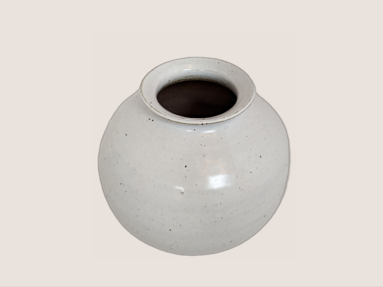 white ceramic vase in round shape, 8 inches tall and 8 inches wide at largest width, with 3.5 inch vase opening. Brown and black speckles give it natural texture and look. 