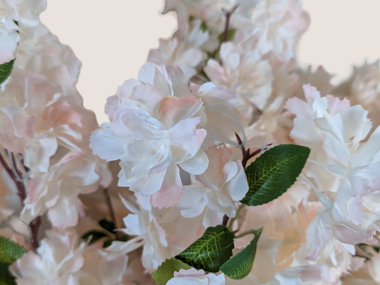 Artificial waterfall cherry blossom stem in soft pink and white, featuring a lifelike brown stem with three branches and fully bloomed big waterfall blossoms. Each branch is 38 inches tall in total, with 16 inches of stem and 22 inches of blossom branches. Pictured against a neutral beige background, this floral stem is perfect for adding a touch of elegance and beauty to any decor.