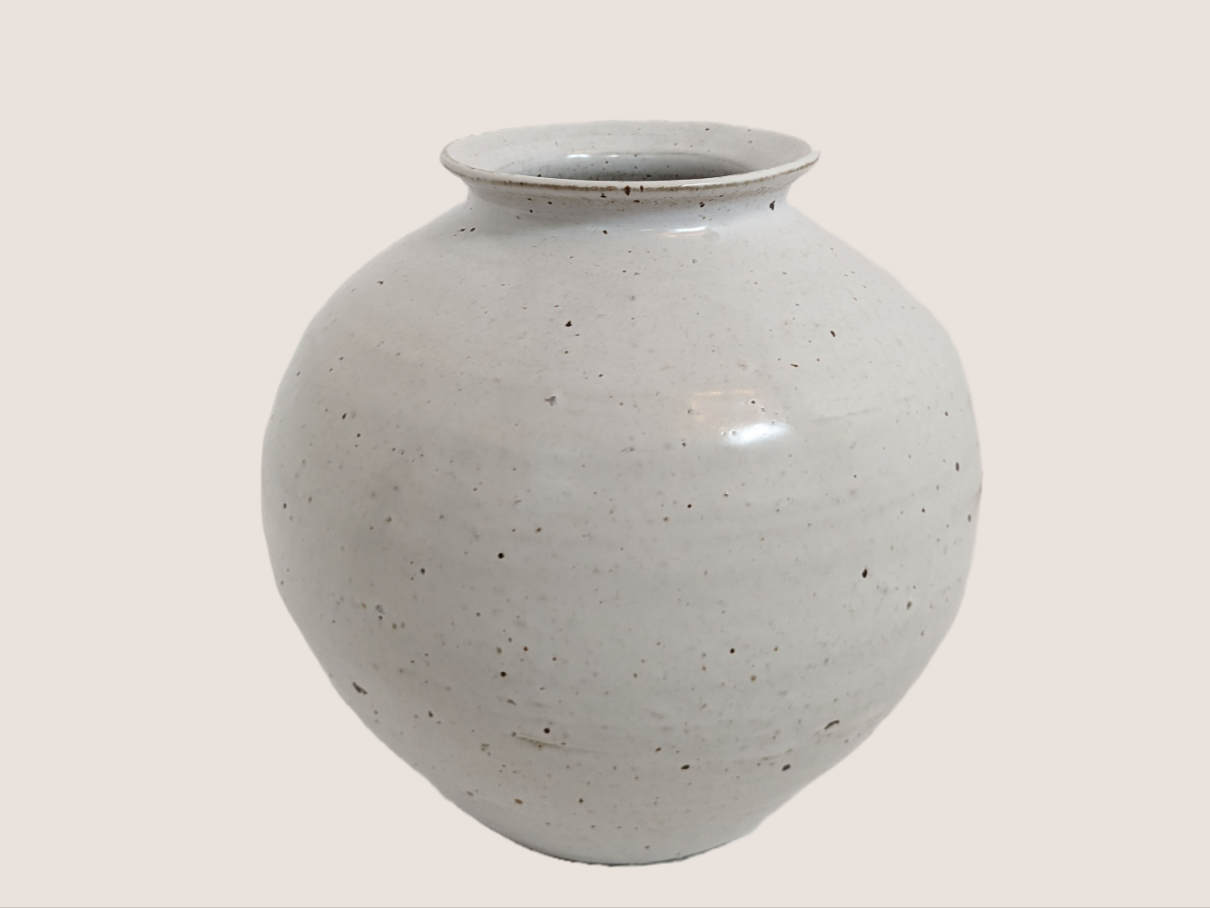 Ivory ceramic vase in round shape with 3.5 inch vase opening. Brown and black speckles give it natural texture and look. 
