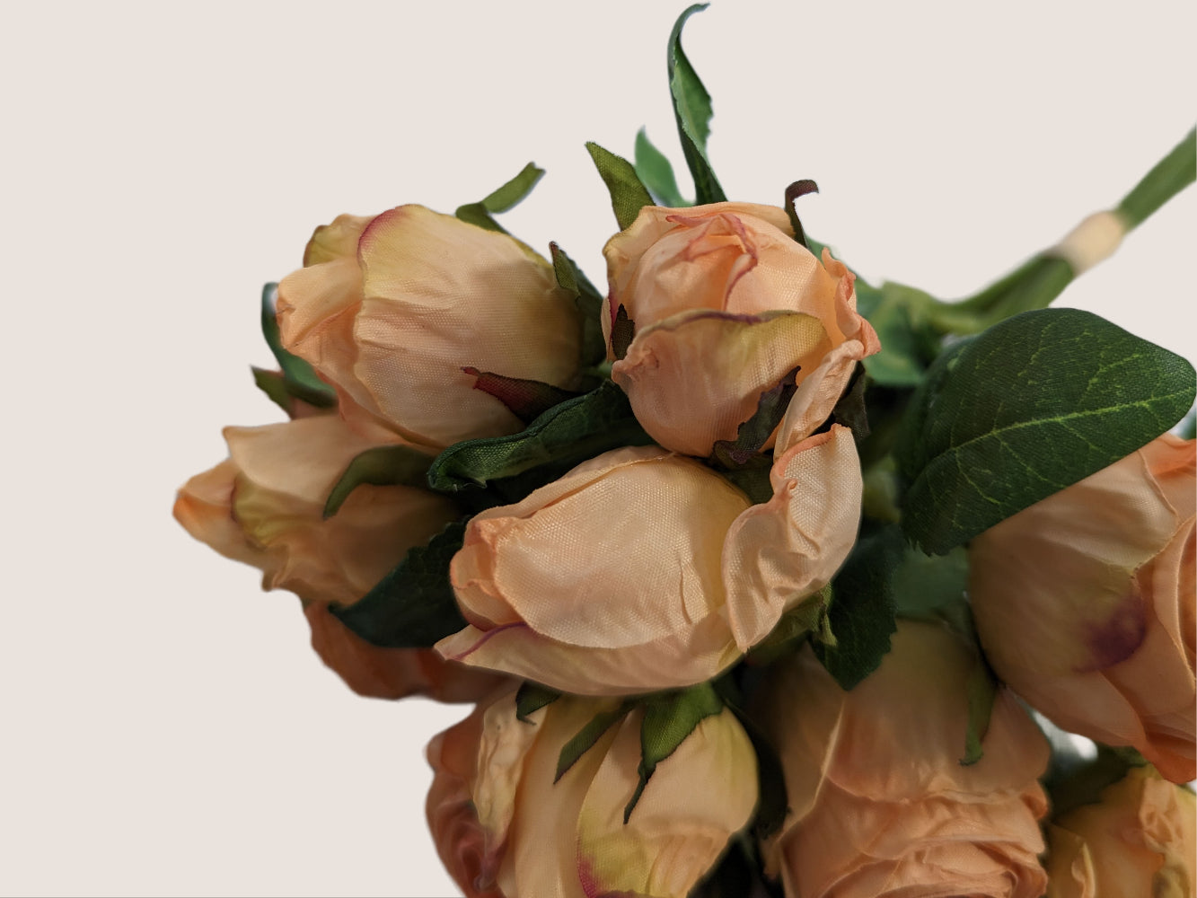 An image of a bouquet of 5 pink roses crafted to look like preserved roses instead of fresh ones. Each stem is 14 inches tall and features two flower heads per green stem. The flowers are pink with light brown edging to look dried, adding to the realistic appearance. The image is against a neutral beige background, showcasing the delicate beauty of the preserved roses.