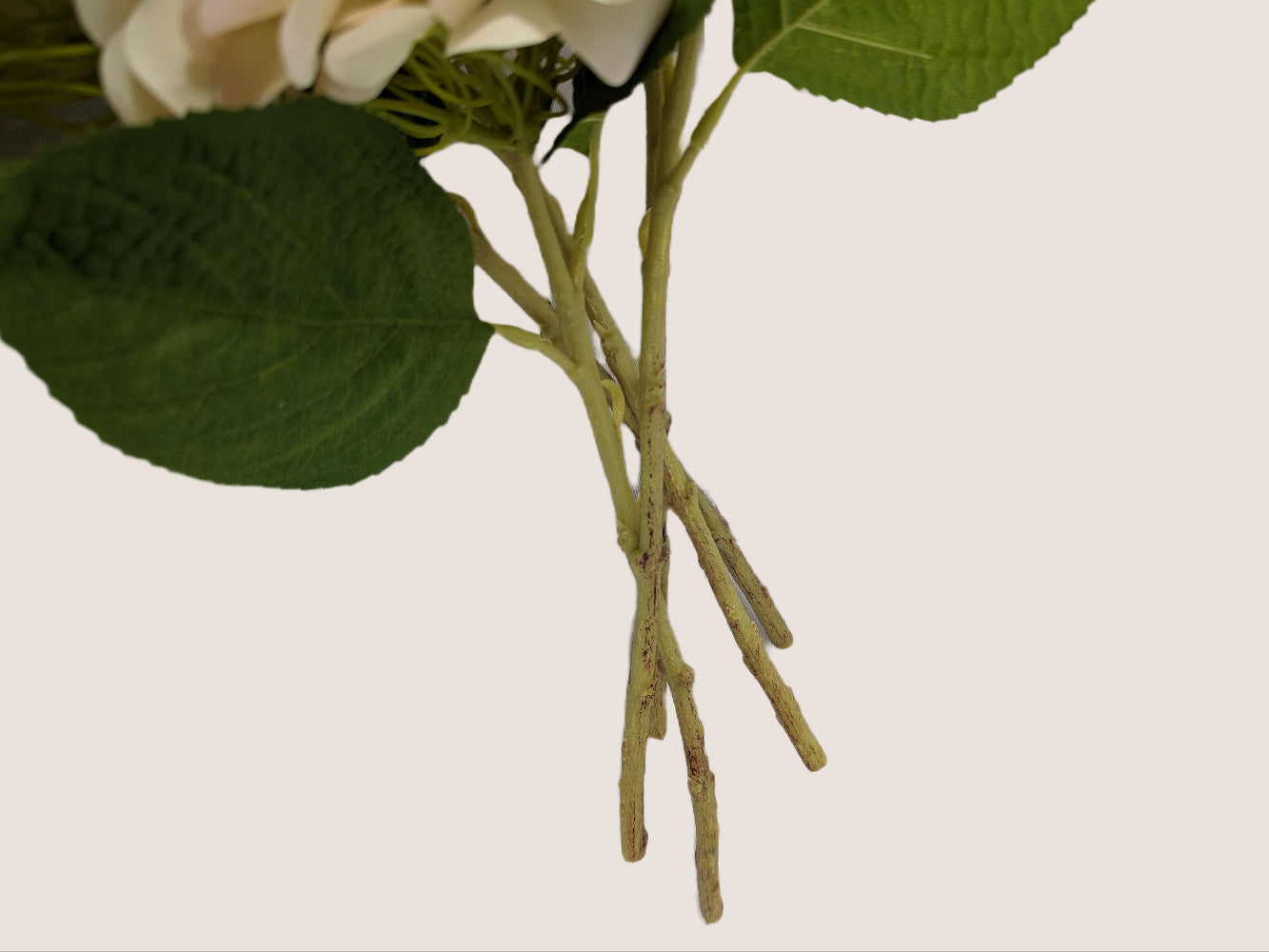 Picture focusing on the stem of an artificial hydrangea which has a color gradient including brown and green, adding to the realism of the flower. The image provides a close-up view of the stem against a white background.